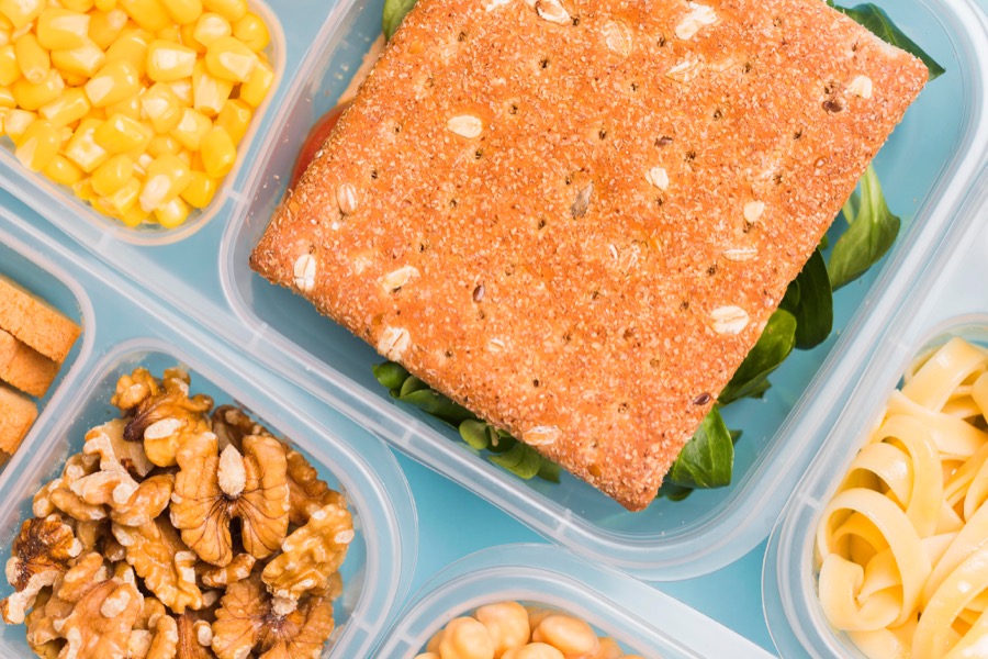 A community dining meal tray with salmon, walnuts, and vegetables